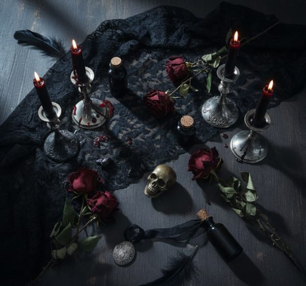 Elegant Gothic Halloween flat lay with candles, vintage lace, dark roses, and moonlight atmosphere.